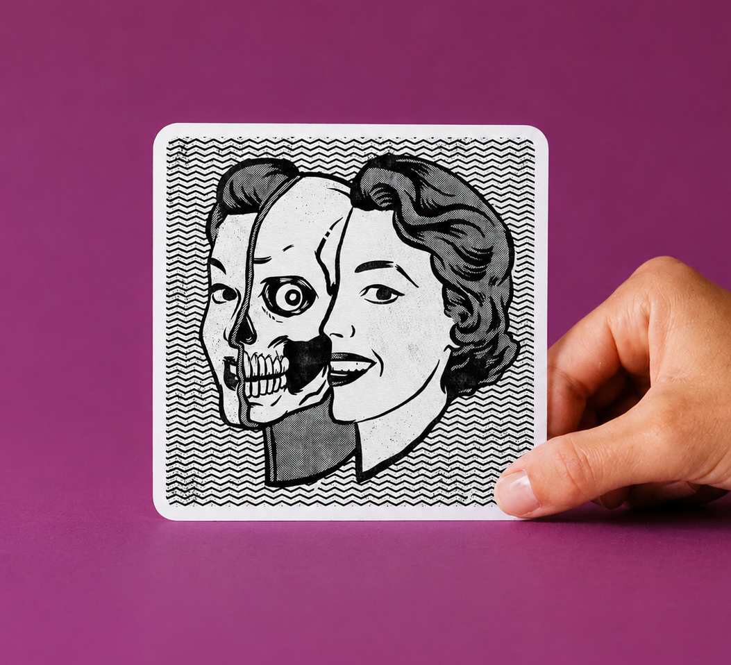 A hand holding a physical card printed with Travis Knight's illustration of a split face — half skull, half woman — on a black and white zigzag background, against a purple background